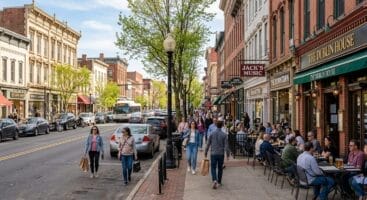 Downtown Red Bank NJ Broad Street with shops and outdoor dining on spring day.